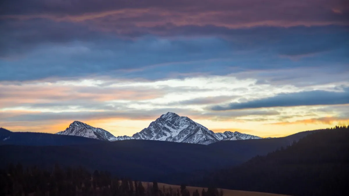 Snow-capped peaks against a pink and gold sky at dusk.