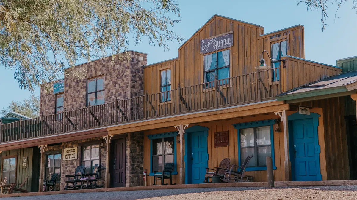 The ranch's Old West street front, with a Grand Hotel sign and blue doors.